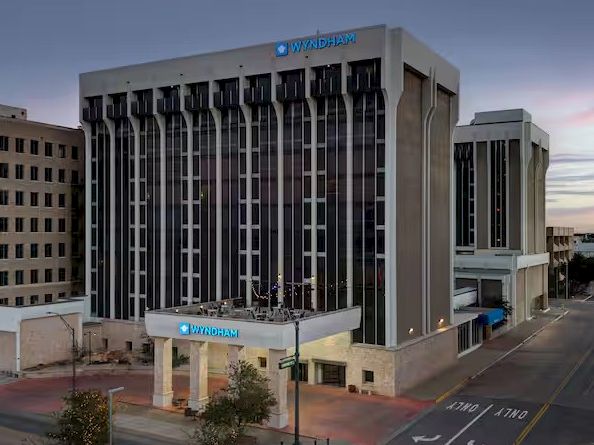 A tall hotel building named TownePlace Suites by Marriott, with a curved entrance canopy and surrounding street, at dusk.